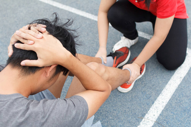 Close up of young asian couple doing sit-ups on the blue running track in stadium - Fotografie, Obrázek