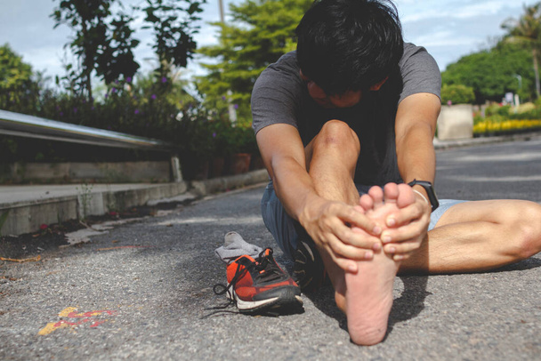 Sport man die pijn in zijn voet voelt na het hardlopen.. - Foto, afbeelding