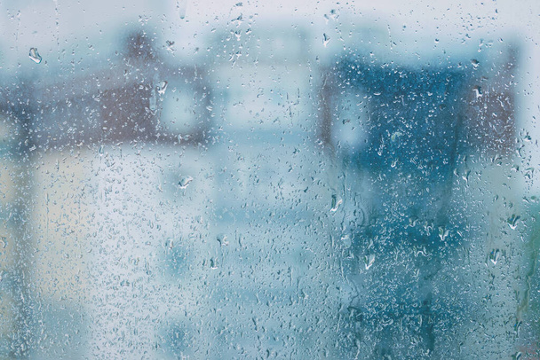 Вид через дощове вікно на розмитий будинок. Погана концепція дощової осінньої погоди
. - Фото, зображення