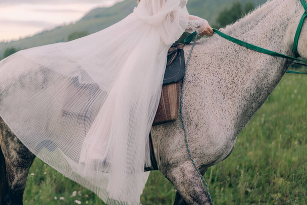 Bride in a wedding dress on a horse - Fotografie, Obrázek