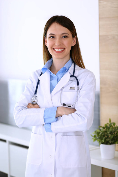 Asian doctor woman happy and cheerful while standing in hospital office. Medicine and health care concept - Φωτογραφία, εικόνα