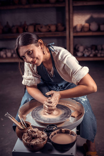 Elegante alfarero maestro mujer posando mientras que la fabricación de loza. Trabajo manual. - Foto, Imagen