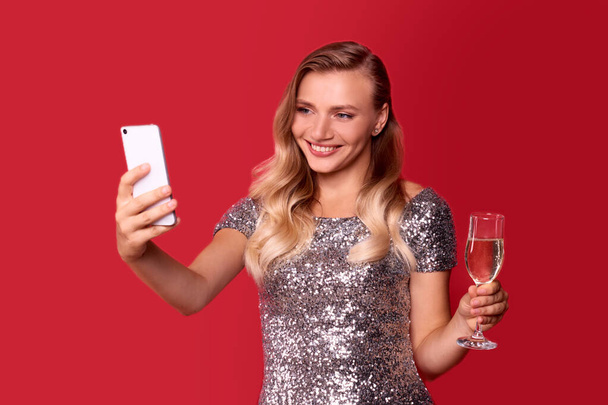 Noël en ligne félicitations de femme souriante en utilisant le téléphone mobile pour les amis d'appel vidéo - Photo, image