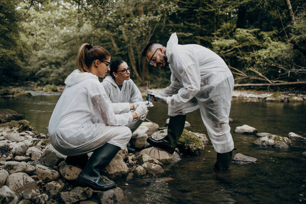 Team of scientists and biologists researching possibilities for bacteria and virus spreading through natural flowing supplies of drinking water. - Фото, зображення
