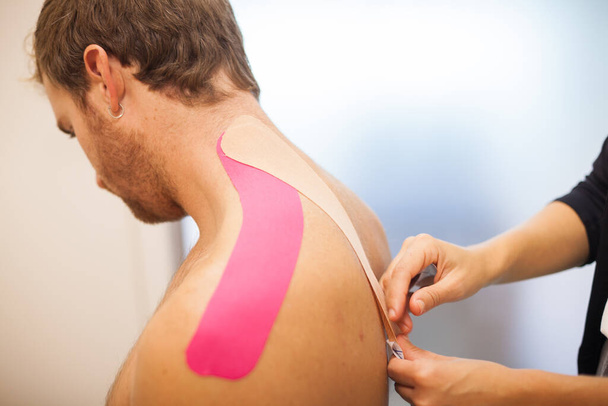 tratamiento de hombro con cinta adhesiva rosa - Foto, Imagen
