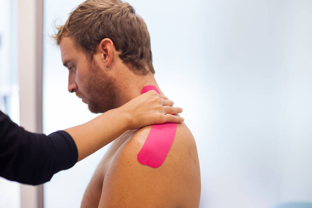 shoulder treatment with pink physio tape - Foto, Bild