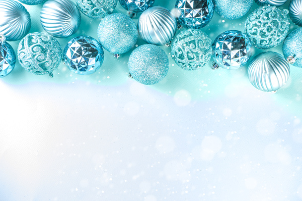 Χριστουγεννιάτικο πανό, φόντο. Μονόχρωμη επίπεδη-lay με διάφορα μπλε μπάλες διακόσμηση των Χριστουγέννων πάνω από γαλάζιο φόντο, top view αντίγραφο χώρου, απλό μοτίβο - Φωτογραφία, εικόνα