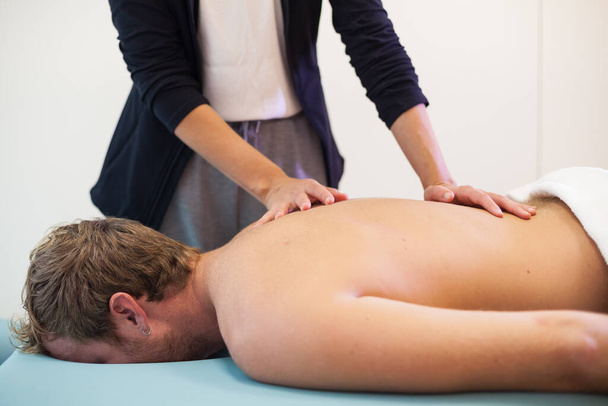 Fisioterapeuta feminina devolvendo massagem ao paciente masculino - Foto, Imagem
