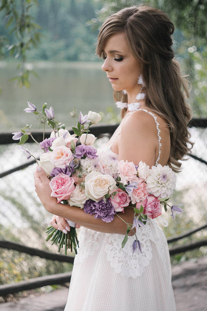 The bride holds a wedding bouquet b - Foto, Imagen