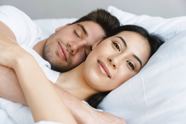 Portrait of young happy loving couple in bed, close up - Fotografie, Obrázek