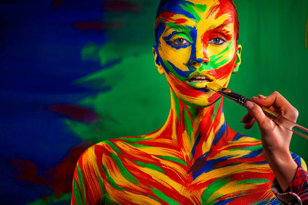 Color art face and body painting on woman for inspiration. Abstract portrait of the bright beautiful girl with colorful make-up and bodyart. - Photo, image