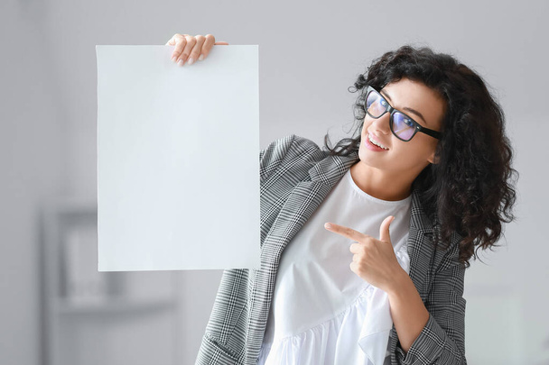 Γυναίκα με λευκό φύλλο χαρτιού στο γραφείο - Φωτογραφία, εικόνα