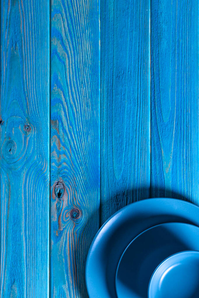 Un juego azul de utensilios se encuentra sobre una mesa de madera azul - Foto, Imagen