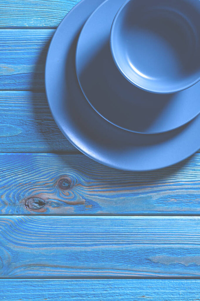 Niebieski komplet naczynia stoi na niebieskim drewnianym stole - Zdjęcie, obraz