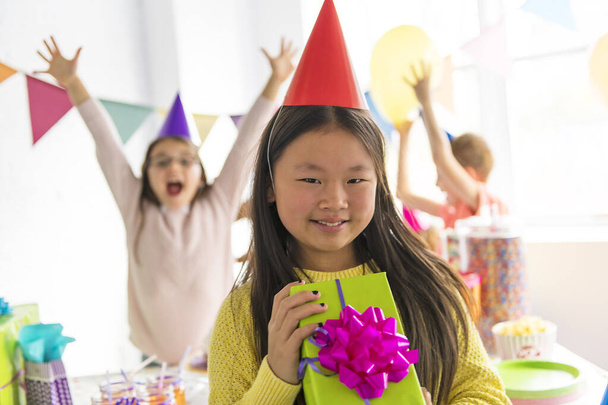 Grupo de adorables niños divirtiéndose en fiesta de cumpleaños asiático en la parte delantera - Foto, imagen