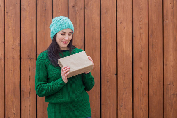 Europäerin im grünen Pullover mit Geschenk  - Foto, Bild