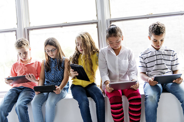 Group of curious children watching stuff on the tablet screen - 写真・画像