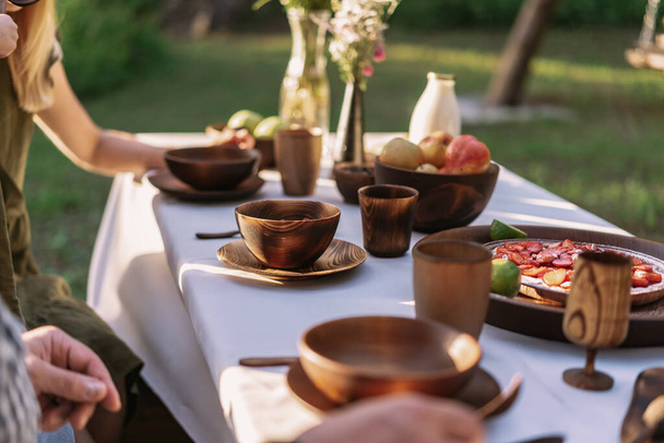 Table served outside with wooden dishes and pie - Photo, Image