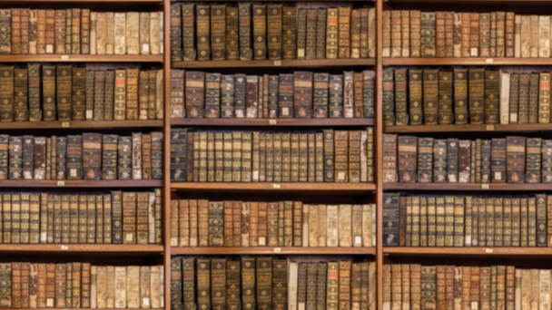 Defocused shelves of old antique books for background in video conference sized to 16 by 9 - Photo, Image