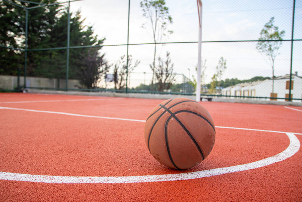Basketball et un panier dans un court extérieur avec éclair dramatique. - Photo, image