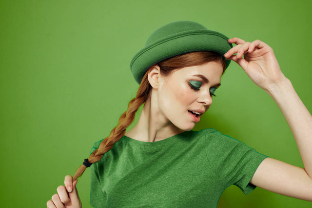 Glückliche Frau mit Shamrock am St. Patricks Day in grünen Kleidern und Hut auf dem Kopf gestikuliert mit den Händen - Foto, Bild