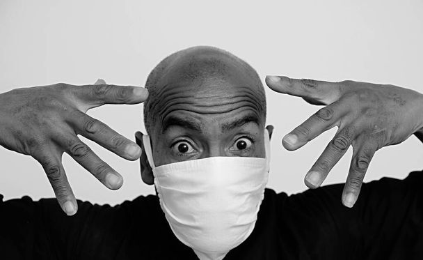 hombre con máscara de polvo luchando contra el brote pandémico del Coronavirus en fondo gris foto de archivo - Foto, imagen