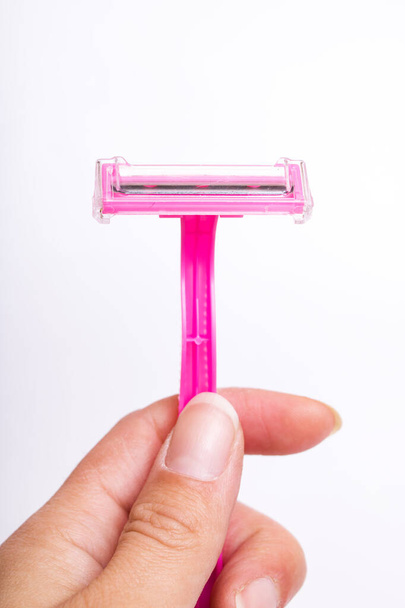 Pink razor in hand on a white background - Photo, image