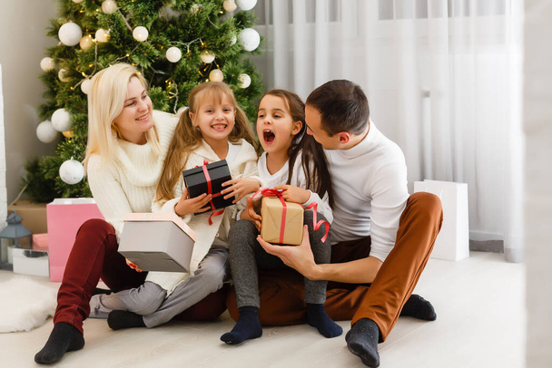 Щаслива родина грає вдома з різдвяними подарунками. - Фото, зображення