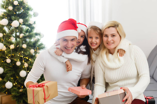 heureux jeune famille tenant cadeau de Noël et souriant à la caméra - Photo, image