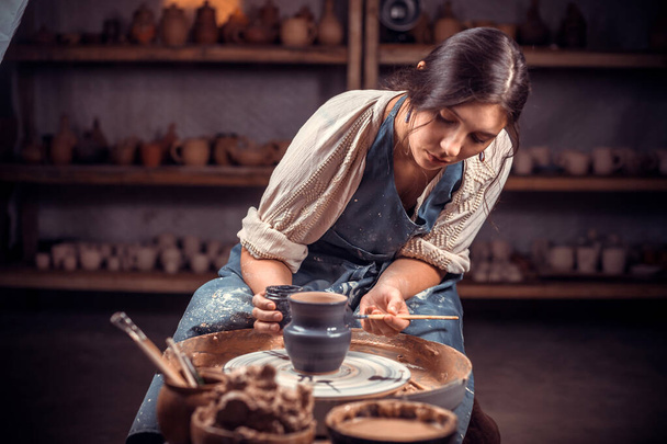 Mooie jonge dame die keramische pot maakt op het aardewerk wiel. Concept voor vrouw in freelance, business, hobby. - Foto, afbeelding