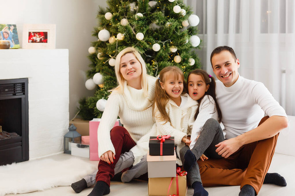 happy young family holding christmas gift and smiling at camera - Foto, Imagen