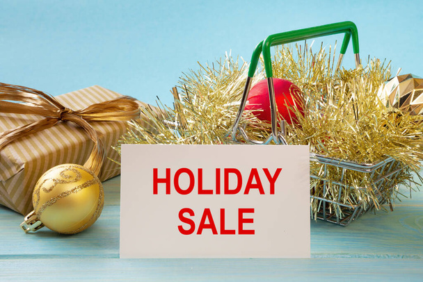 Shopping cart and text HOLIDAY SALE on white paper note list. Shopping list concept. - 写真・画像