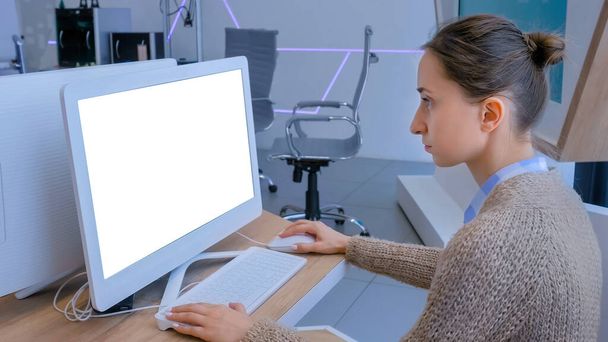 白いディスプレイとデスクトップコンピュータのモニターを見ている女性 - 写真・画像