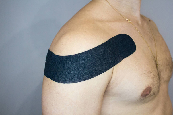 Kinesiotaping, Kinesiologie-Klebeband - Anwendung für Schmerztaping am Mann Medizin Rehabilitation - Foto, Bild