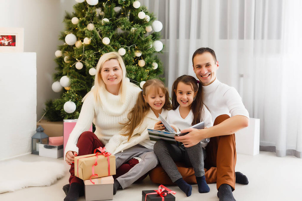 Barátságos család portréja, ahogy a kamerába néznek karácsony este - Fotó, kép