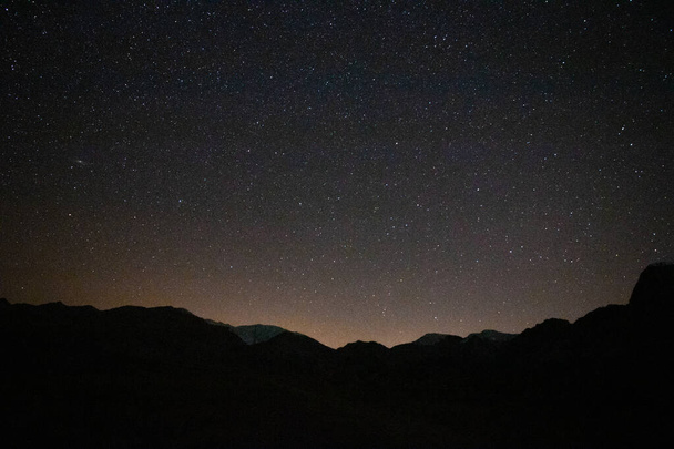Stars and hills with a little city light pollution - 写真・画像