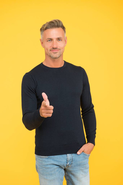 stylish mature guy with trendy hairstyle wearing black pointing finger, male fashion - Foto, Imagem