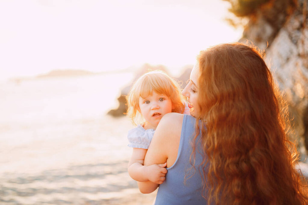 Matka delikatnie trzyma córeczkę w ramionach - Zdjęcie, obraz