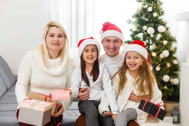 happy young family holding christmas gift and smiling at camera - Photo, Image