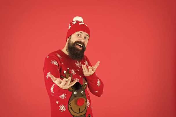 Join holiday party. Christmas Sweater Party. Winter outfit. Good vibes. Fashion shop. Winter bucket list. Hipster bearded man wear winter sweater and hat red background. Happy new year concept - Foto, afbeelding