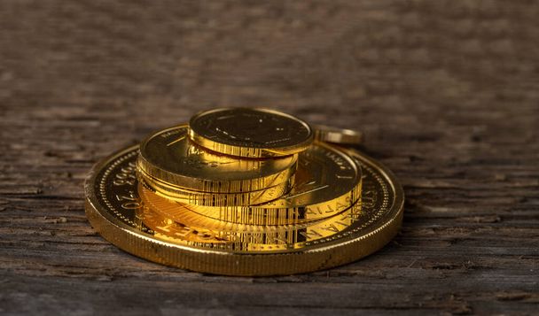 Několik zlatých mincí ryzosti 999.9 na pozadí surového dřeva textury. - Fotografie, Obrázek