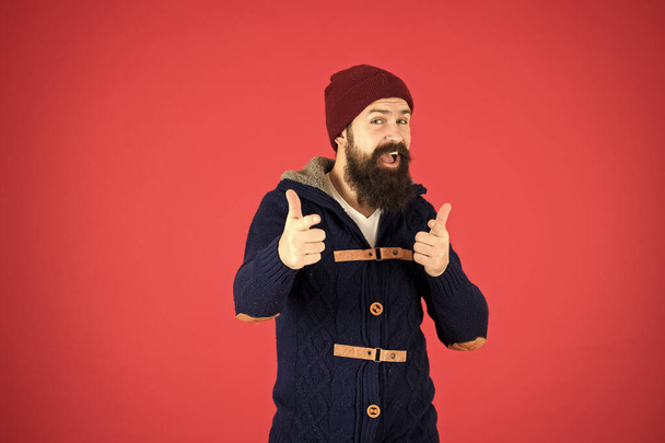 Winter menswear. Clothes design. Man bearded warm jumper and hat red background. Winter season menswear. Personal stylist. Warm and comfortable. Fashion menswear shop. Masculine clothes concept - Photo, Image