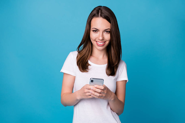 Portrait of positive cheerful girl use smartphone follow post comment social media news wear good look clothes isolated over blue color background - Foto, Imagen
