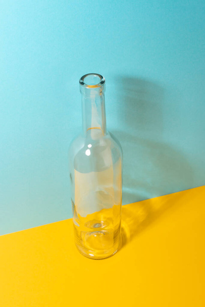 Empty transparent glass bottle on colorful background - Photo, image
