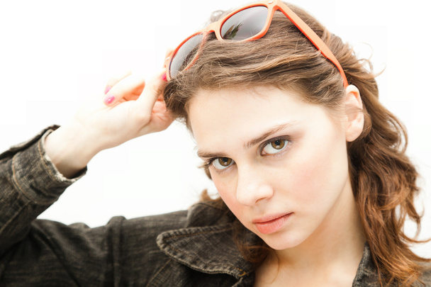 Beautiful young woman puts on sunglasses, isolated on white  - Valokuva, kuva