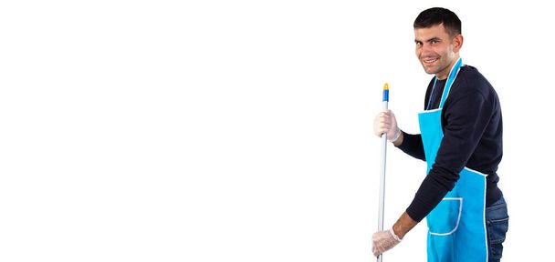 Banner, long format. A man in an apron mops the floor with a mop and smiles at the camera. Photo on white background with empty side space. High quality photo - Valokuva, kuva