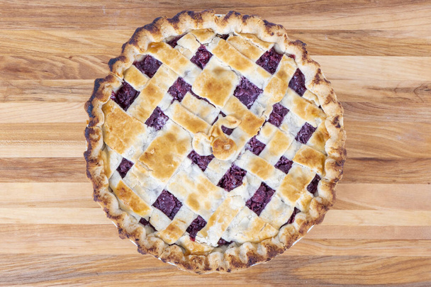 Closeup of Cooked Cherry Pie on a Wood Cutting Board - 写真・画像