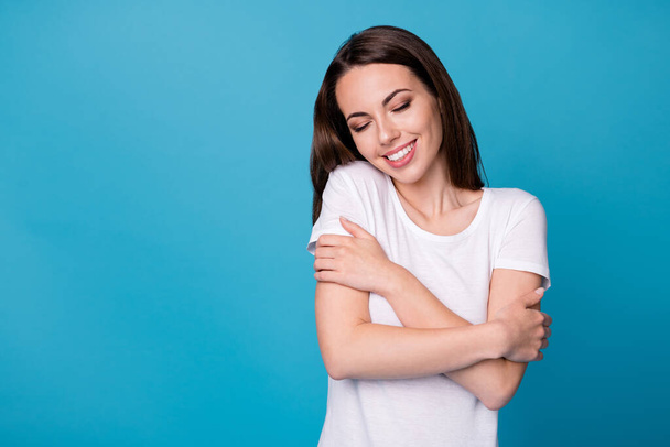 Photo of positive cheerful girl hug herself enjoy cuddle wear casual style outfit isolated over blue color background - Φωτογραφία, εικόνα