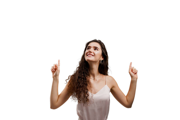 Girl points up and gives 2 variants to choose. Attractive young woman is pointing up and smiles isolated on white background. Advert for sale promotions, discounts, black friday. - Photo, Image