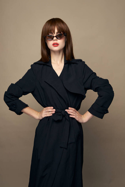 Luxuriöses Modell dunkler Mantel attraktives Aussehen Freude auf einem isolierten Hintergrund  - Foto, Bild